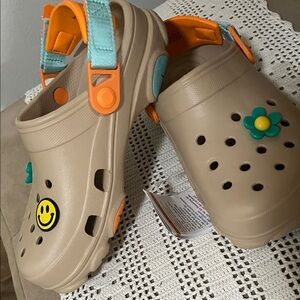 Women’s classic all terrain Crocs Tan with Smiley and Flower Accents size 7 NWT